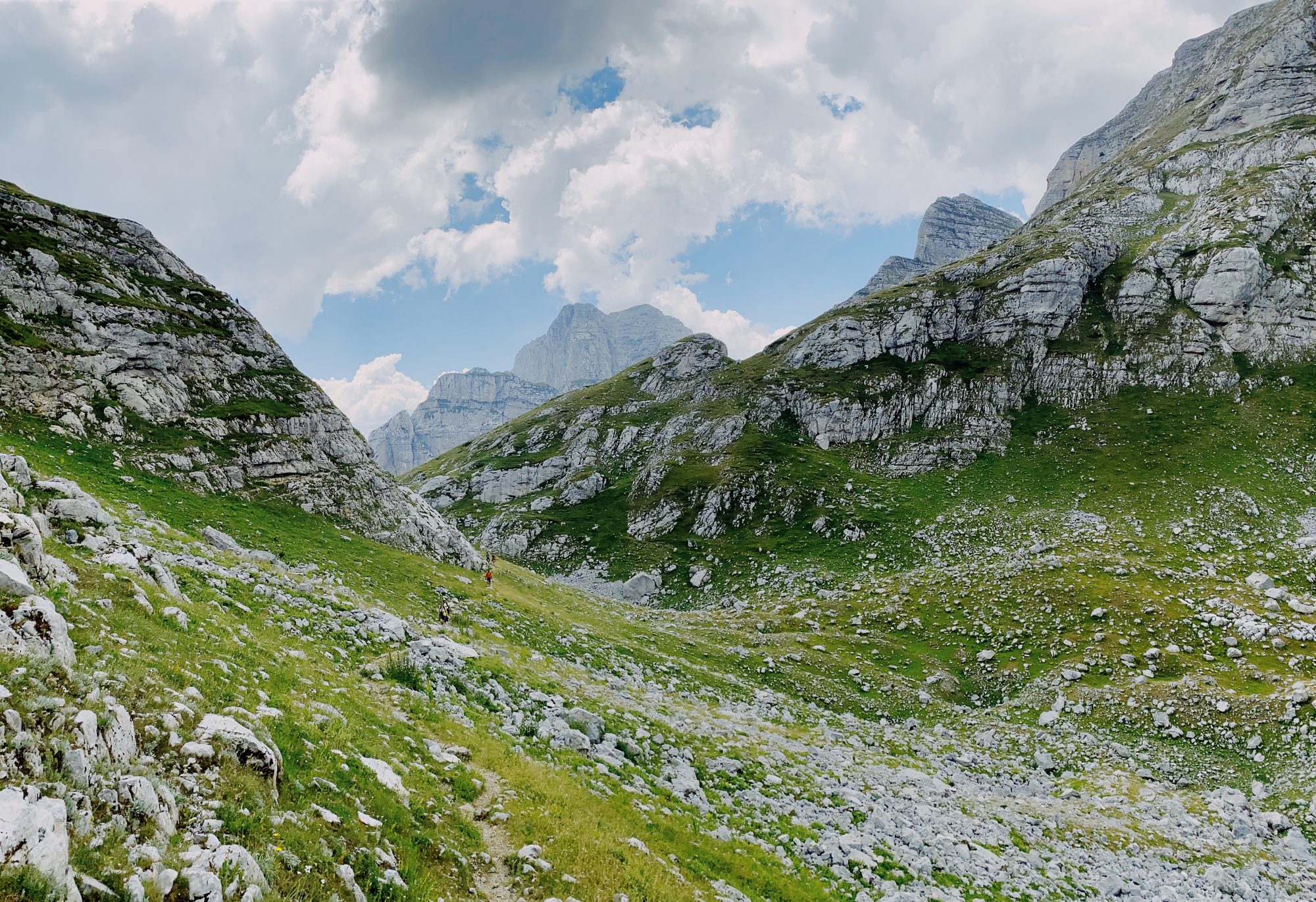 The Accursed Mountains in northern Albania seen from a pass in Valbona Valley, jagged limestone peaks under a clear sky.