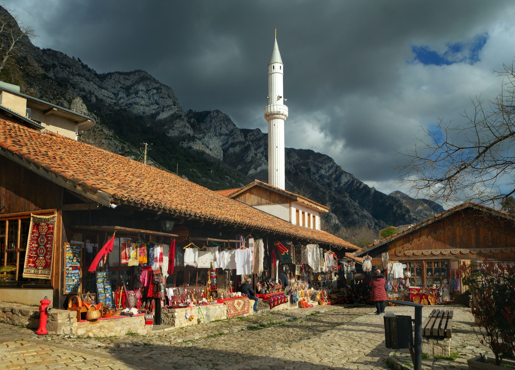 A narrow cobbled street lined with wooden-fronted shops selling carpets, copperware and antiques.