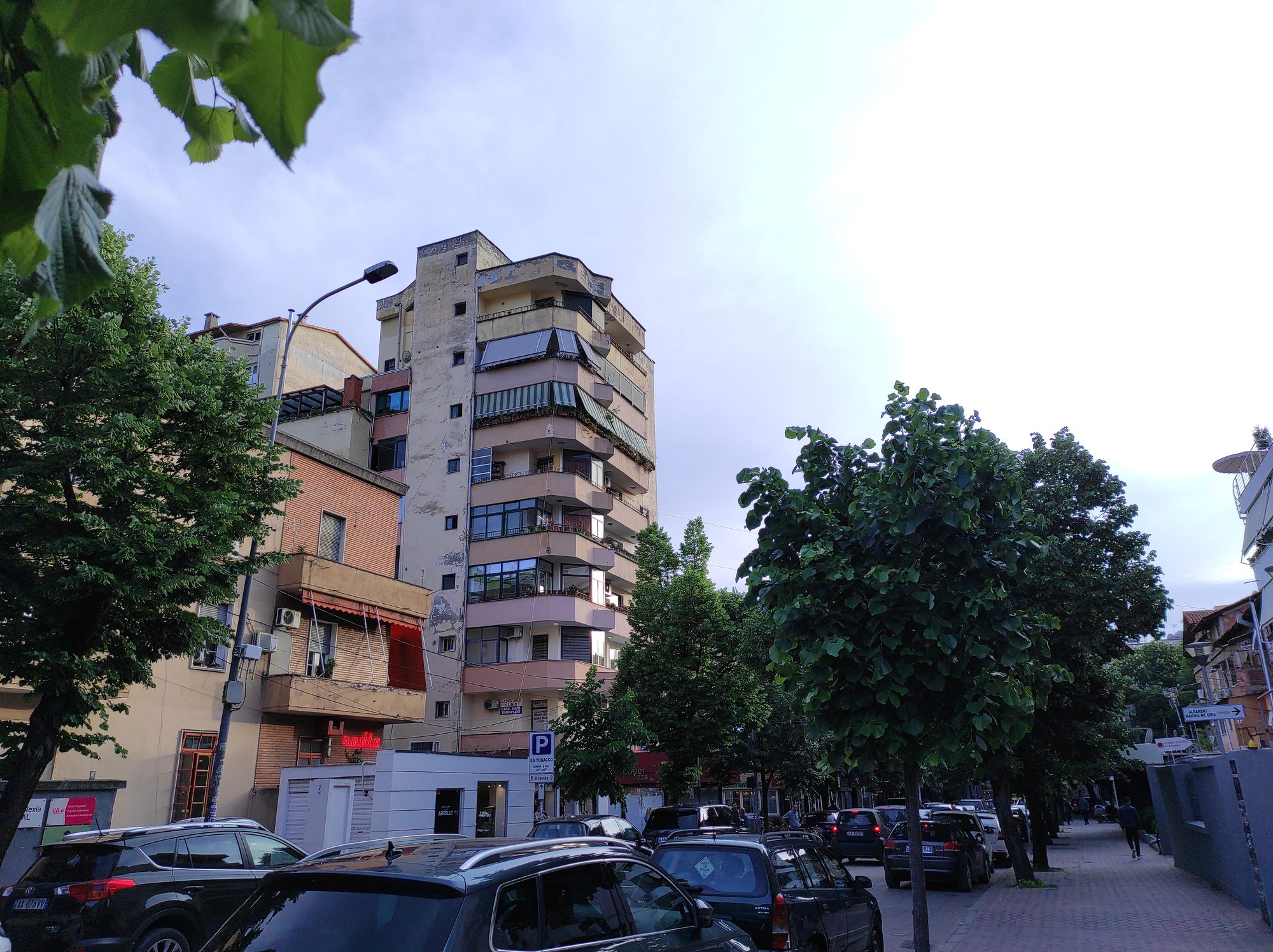 Modern apartment towers and older painted blocks packed together in a city neighbourhood, seen from above.